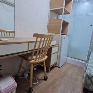 部屋の中には、机と椅子が置かれています。机の上には、コンピューターやその他の物品が置かれています。部屋の奥には、棚やタンスなどの収納家具が設置されています。部屋全体が明るく、清潔な印象を受けます。