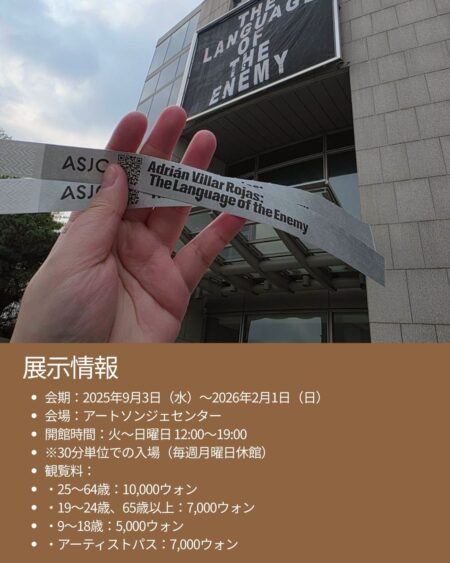 アートソンジェセンターの外観。建物正面に〈THE LANGUAGE OF THE ENEMY〉と書かれた大きなバナーが設置され、展示紹介テキストが重ねて表示されている。