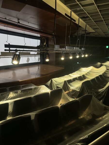 ビニールで覆われた客席と舞台照明が並ぶ空間。展示によって劇場のような場所が別の用途へと変容している様子。