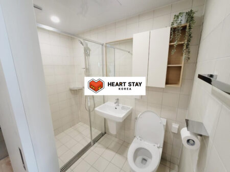 広々としたシャワーブースと収納付き洗面台が特徴のオフィステル浴室