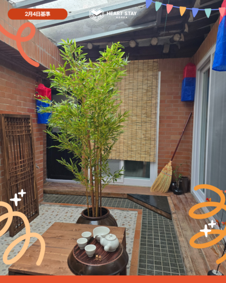 韓屋中庭スペース。植物とテーブルがあり、ゆったりと過ごせる共有エリア。